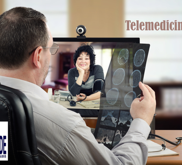 Mature male consultant adult neurosurgeon attentively looks at patients brain x-ray results. Doctor sits at the desk opposite monitor with web-cam where middle-aged cheerful woman measures her blood pressure. Horizontal indoors shot on blurry office background